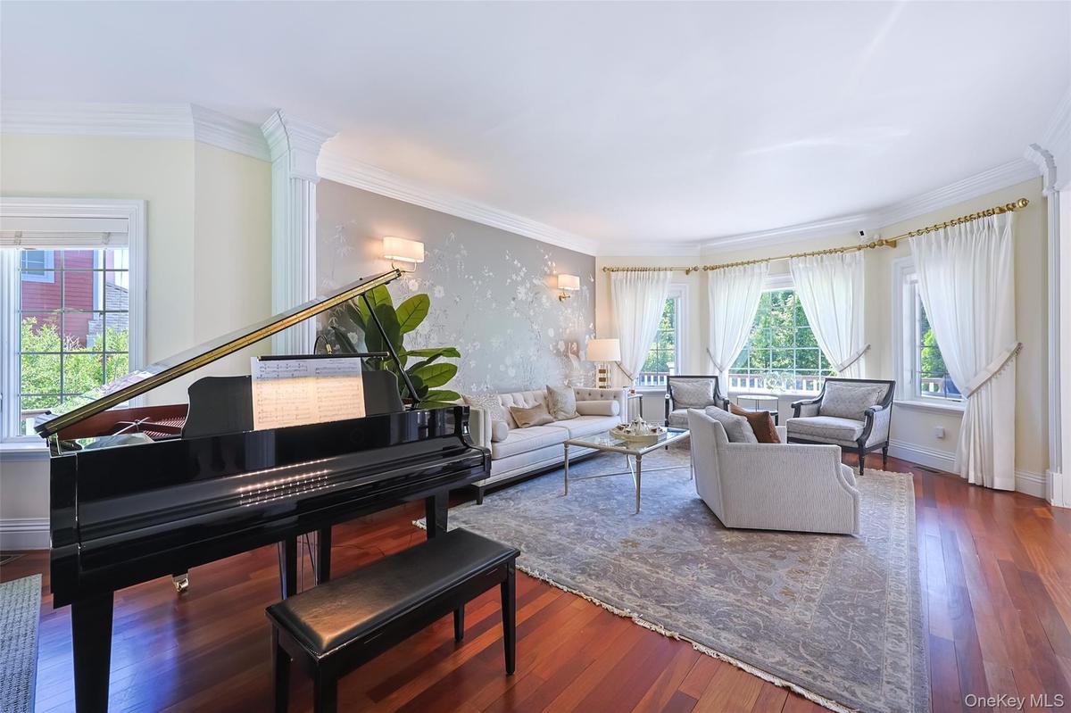 Spacious living area featuring polished wood flooring and a bay window configuration