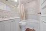 Bathroom featuring a white vanity with a marble countertop, undermount sink, and chrome faucet