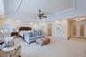 Spacious room featuring a tray ceiling with recessed lighting, crown molding, and a ceiling fan