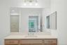 Oversized light wood vanity with new quartz countertops, under mount porcelain sink and Kohler Faucet