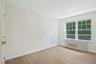 Bedroom with dimmable overhead lighting, wood floors, large closet and remote controlled motorized shades