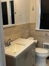 Bathroom featuring a gray vanity with integrated sink, chrome faucet, and coordinating cabinet hardware