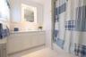 Bathroom featuring vanity, tile patterned floors, a wainscoted wall, shower / bath combo, and toilet