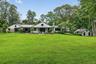 Back of the home on a glorious 5.5 arboretum like acres.