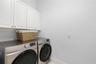 Laundry room - 2 sets of cabinets and counter folding space with sink across from washer/dryer