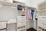 1 of 2 walk in closets in Primary Suite with custom closet system