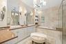 Primary bath with luxury lighting, travertine accent walls. Separate whirlpool bath and large walk in shower. Stone counters.