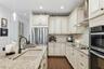 The French Country cabinetry has brass style finishes