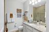 The second full bathroom upstairs features a tub and shower combination, granite counters and French Country cabinets