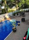 Expansive outdoor living area featuring a rectangular swimming pool with integrated steps, brick paver patio, and a privacy fence