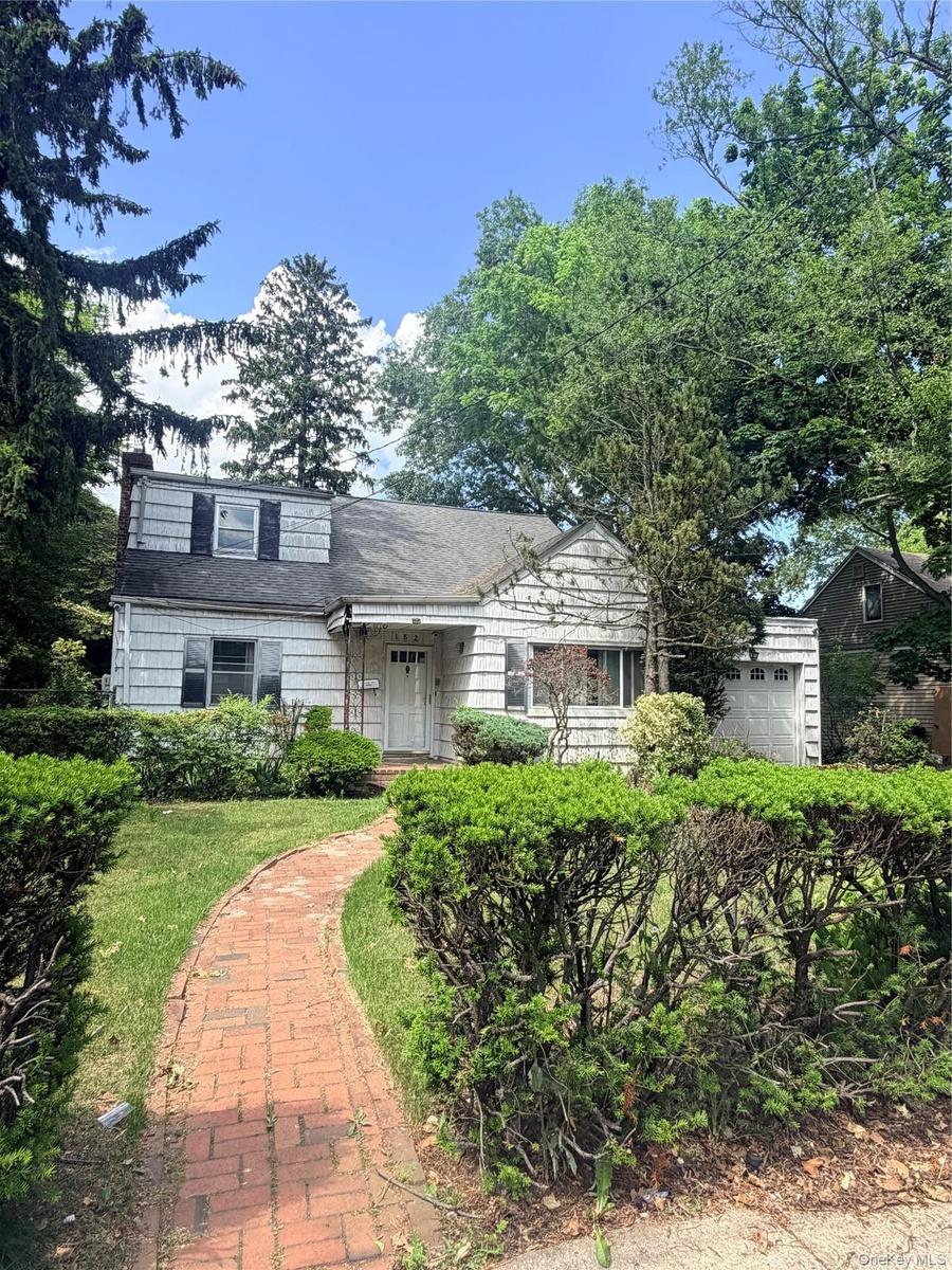 Traditional-style residence featuring white siding and a dormer window