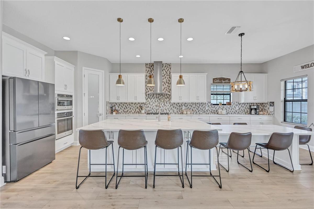 Gourmet kitchen featuring stainless steel appliances, gas cooktop, ample prep space & abundant cabinetry.
