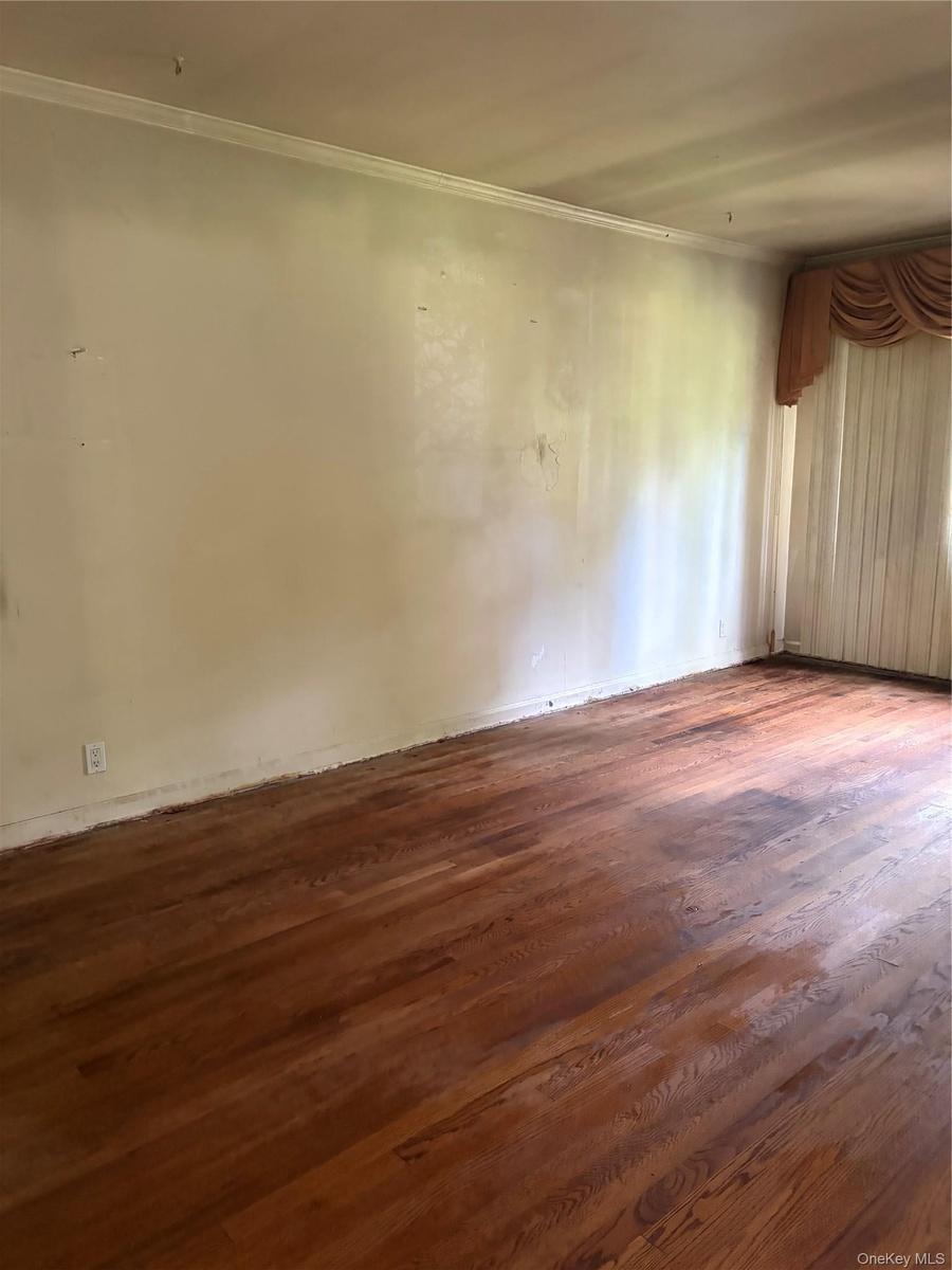 Hardwood flooring extends throughout this livingroom, complemented by white walls and ceiling trim
