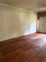 Hardwood flooring extends throughout this livingroom, complemented by white walls and ceiling trim