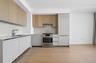 Modern kitchen with light wood-finish upper cabinetry and white lower cabinetry