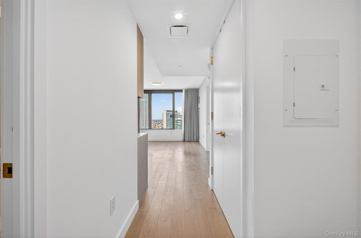 Hallway entry featuring wood-finish flooring and a bright, neutral color palette