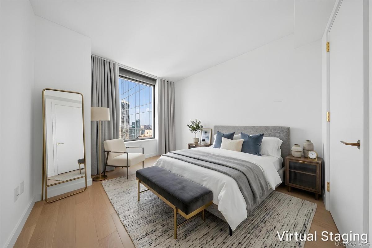 Bedroom featuring expansive window, light wood-finish flooring, and crisp white walls