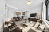 Open-concept living space featuring wood-finish flooring, a contemporary kitchen with light wood-finish cabinetry, and a dining area