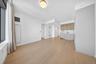 Open-concept living area with light wood-finish flooring, recessed ceiling lighting, and a modern flush-mount light fixture