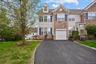 Multi-level townhome featuring stone and siding facade, an integrated garage, and a paved driveway