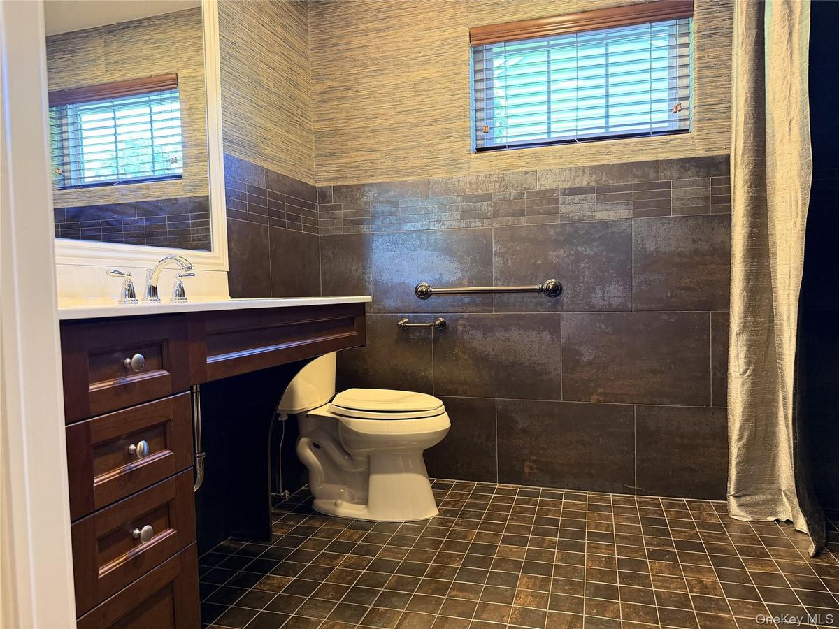Bathroom featuring a dark wood vanity with a white countertop and chrome fixtures