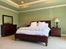 Principal bedroom featuring a tray ceiling with recessed lighting and crown molding