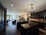 Gourmet kitchen featuring dark wood-finish cabinetry, granite countertops, and a full-height tile backsplash
