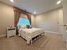Carpeted room featuring a window with custom drapery, recessed lighting, and a paneled door
