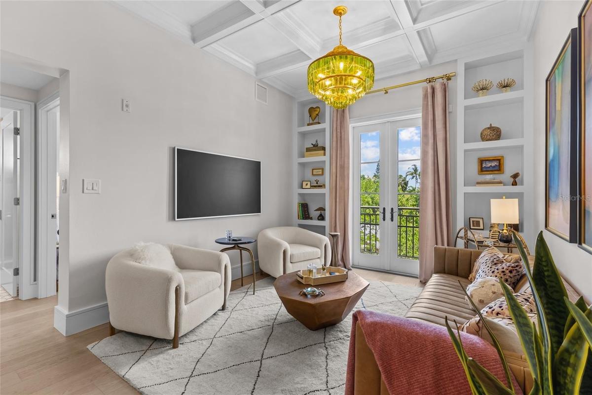 Living room with built in shelving a french doors to patio