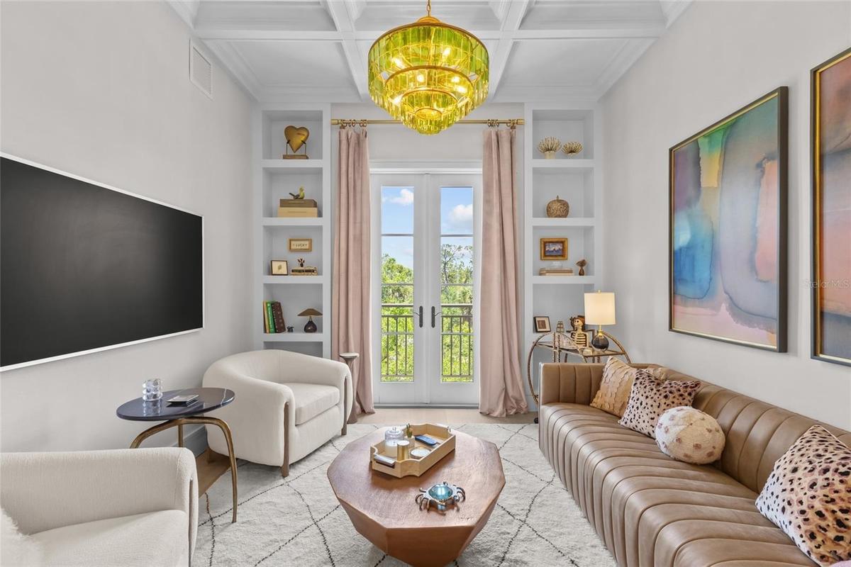 Living room with built in shelving a french doors to patio