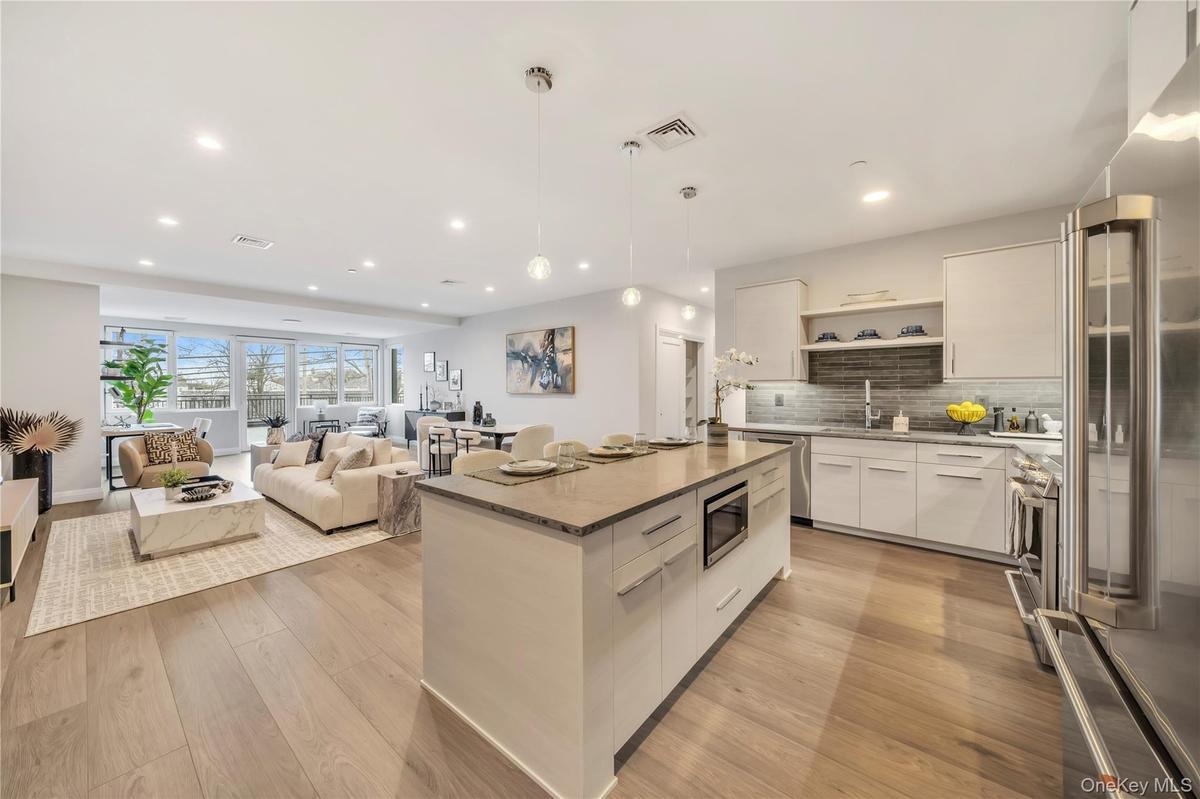 Kitchen with visible vents, appliances with stainless steel finishes, modern cabinets, open shelves, and a sink