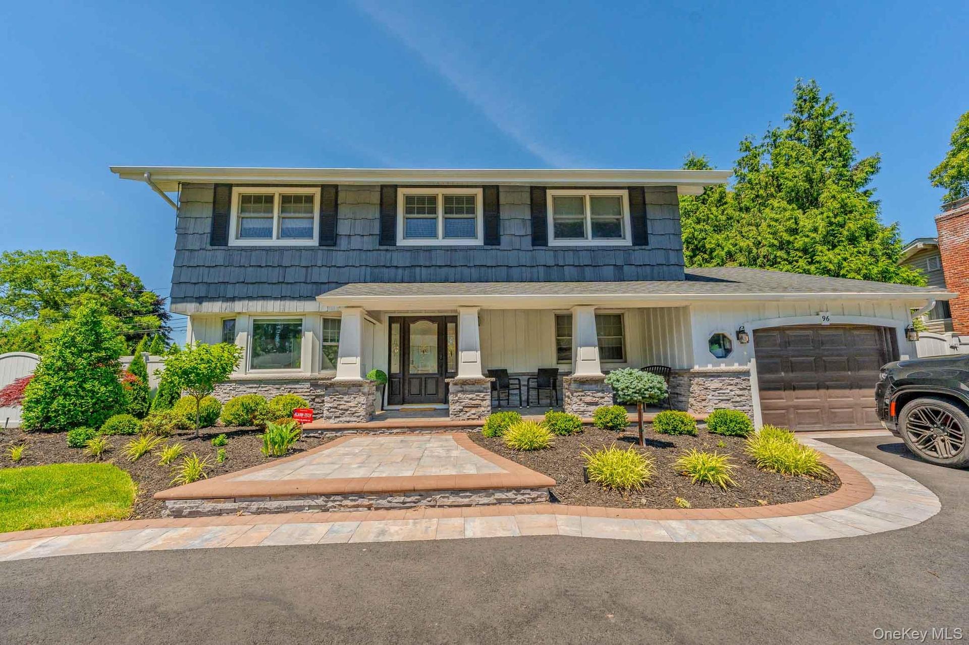 Magnificent backyard oasis featuring a pristine in-ground pool, expansive stone patio perfect for outdoor dining, and a beautifully manicured, private