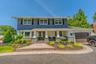 Magnificent backyard oasis featuring a pristine in-ground pool, expansive stone patio perfect for outdoor dining, and a beautifully manicured, private