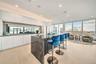 Kitchen with white cabinets, light wood-type flooring, a kitchen island, a kitchen bar, and modern cabinets