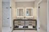 Bathroom with double vanity, a sink, and tiled shower