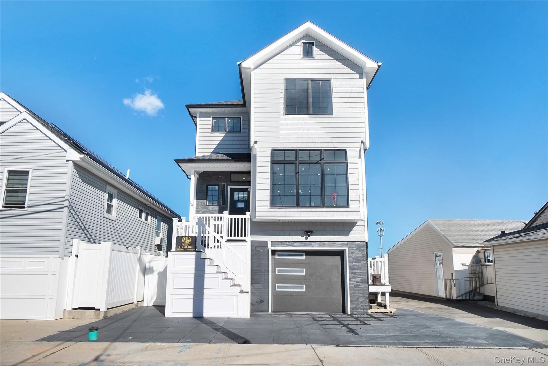View of front of property featuring an attached garage, stairway, and driveway