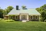 Contemporary architect-designed residence featuring a standing seam metal roof, central cupola, and multi-pane windows