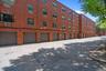 Multi-story brick building facade featuring multiple garage bays