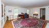 Spacious interior room featuring hardwood flooring and white paneled walls