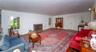 Spacious room featuring wood-finish flooring, a brick fireplace with a white mantel, and built-in shelving