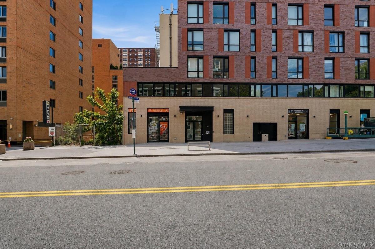 Modern brick and block facade building with ground-level retail spaces and upper-level residences