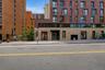 Modern brick and block facade building with ground-level retail spaces and upper-level residences