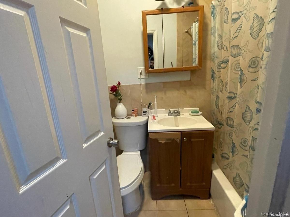 Bathroom with toilet, tile patterned flooring, and vanity