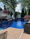 In-ground pool featuring a white slide and blue mosaic-tile liner installed 5/2026