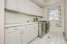 Laundry area featuring a baseboard heating unit, light tile patterned flooring, cabinet space, and independent washer and dryer