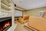 Cinema featuring light colored carpet, a fireplace with flush hearth, and a drop ceiling