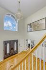 Entryway with a chandelier, wood finished floors, stairs, a towering ceiling, and a baseboard heating unit
