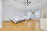 Bedroom featuring a tray ceiling, light wood finished floors, a baseboard heating unit, and a ceiling fan