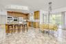 Kitchen featuring decorative backsplash, a kitchen bar, an island with sink, decorative light fixtures, and appliances with stainless steel finishes