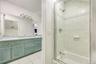 Full bath featuring light tile patterned floors, double vanity, and washtub / shower combination